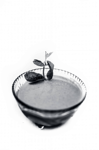 Close up shot of popular Indian sauce or chutney i.e. Phudina ki chutney isolated on white in a transparent glass bowl. - Фото, изображение