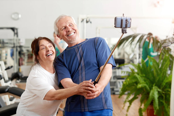 Lachende ouderen paar nemen selfie in Gym. - Foto, afbeelding