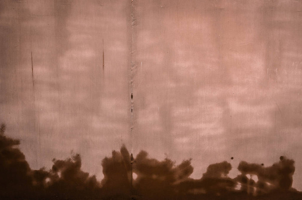 Tekstura jasnobrązowej ściany z mokrymi plamami. Tapety fo - Zdjęcie, obraz