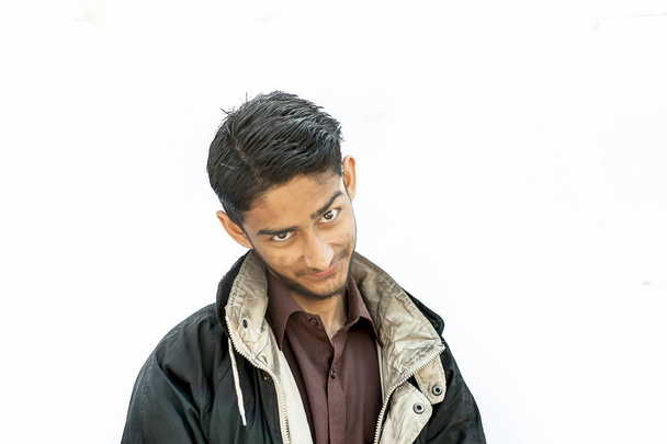 Portrait shot of a young beard man wearing brown colored shirt and a black colored jacket expressing or looking at the camera by surprised face or with curiosity or sometimes hilarious faces. - Photo, image