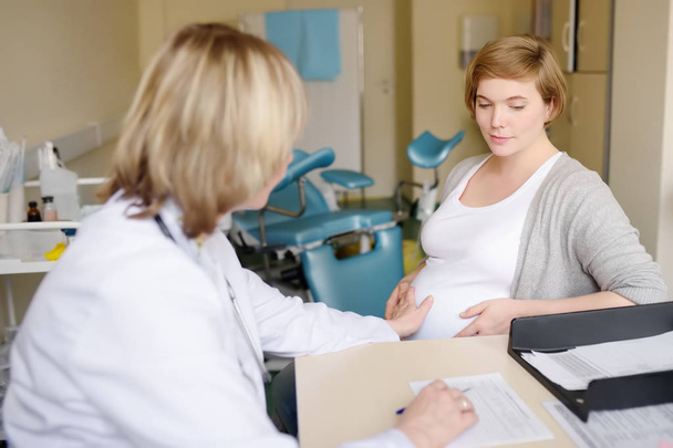 Gynekologi lääkäri hyväksyy raskaana olevan naisen. Hedelmällinen sairausvakuutus. Raskauden perhelääkäri. Äitiysvapaa
. - Valokuva, kuva