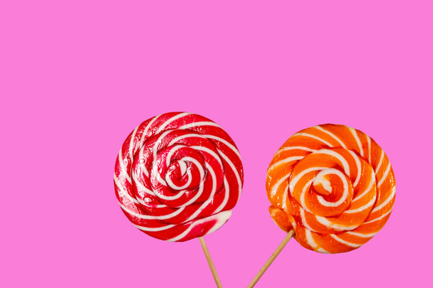 Red and orange lollipops on pink background - Photo, Image
