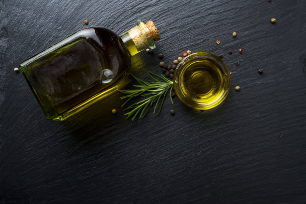 Virgin olive oil in a glass bottle and rosemary - Foto, Imagen