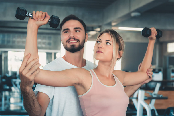 Portrait of Couple Love in Fitness Training With Dumbbell Equipment., Young Couple Caucasian are Working Out and Training Together in Gym Club., Sport and Healthy Concept. - Photo, image