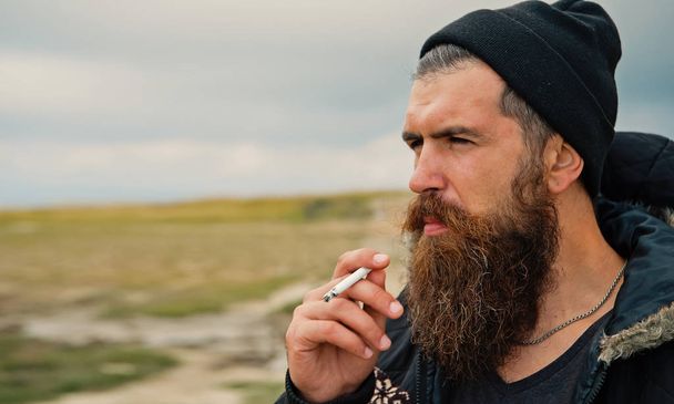 man hipster or guy with beard and moustache smoking cigarette - Foto, Imagen