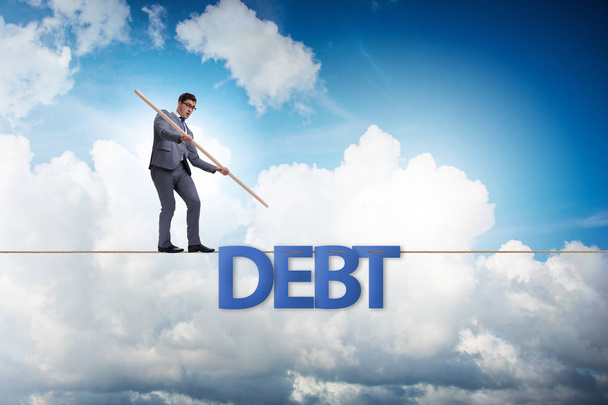Adósság-és hitel koncepció üzletember séta szűk kötelet - Fotó, kép