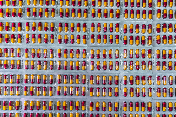 Tabletki kapsułki antybiotyk w blistrze na linii produkcyjnej fabryki produkcji farmaceutycznej. Branża farmaceutyczna i koncepcja farmaceutyków. Antybiotykooporność leków. Pakowanie pigułek. - Zdjęcie, obraz