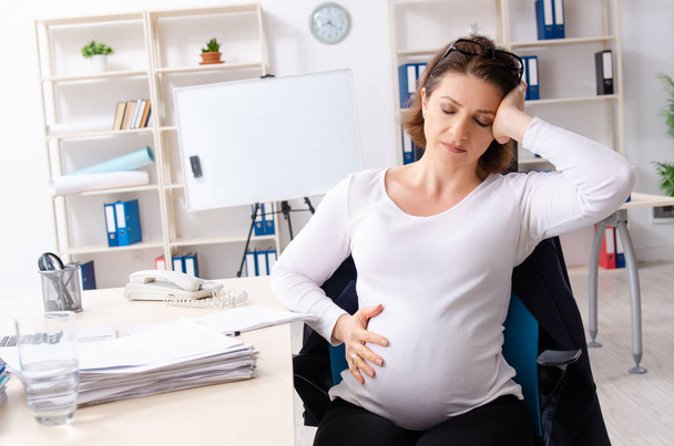 Ofiste çalışan hamile bir kadın.  - Fotoğraf, Görsel