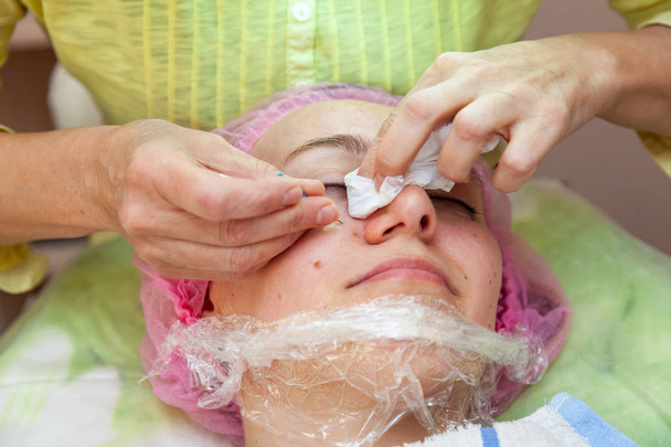 Une fille est allongée sur le canapé pendant les procédures cosmétiques avec un masque
  - Photo, image