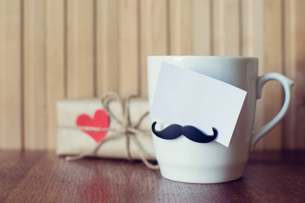 Carte de voeux sur la tasse avec une drôle de moustache sur une planche en bois. La fête des pères. Joyeux anniversaire. Saint Valentin. Maquette
 - Photo, image