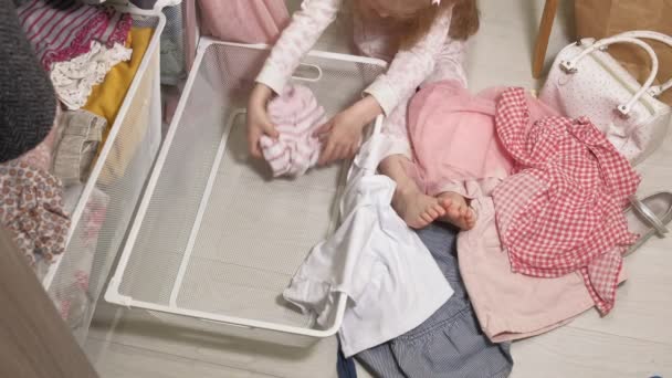 Маленькая девочка убирает одежду в домашнем шкафу
 - Кадры, видео