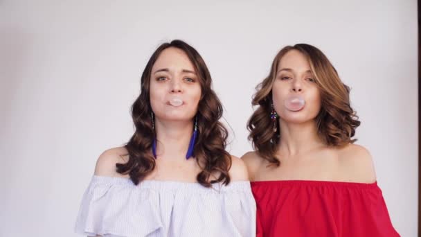 Jumelles filles soufflant chewing-gum en bulles
. - Séquence, vidéo