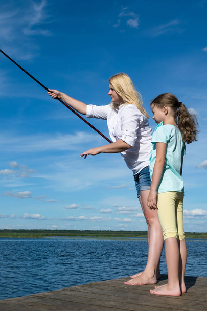 woman with her daughter is fishing in sunny weather - Foto, Imagem
