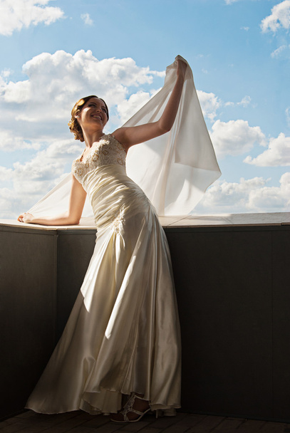Happy beautiful bride with flying fabric over sky - Foto, Bild