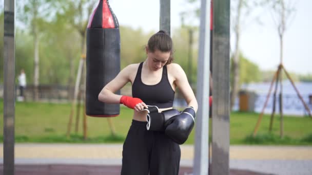 4k.Young pugile donna, kickboxer indossare guanti su strada campo di allenamento. Pronti a combattere
!  - Filmati, video