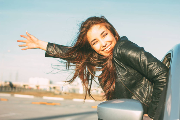 Happpy belle brune charmante cheveux longs jeune femme asiatique en cuir noir veste dans la fenêtre de la voiture au coucher du soleil
 - Photo, image