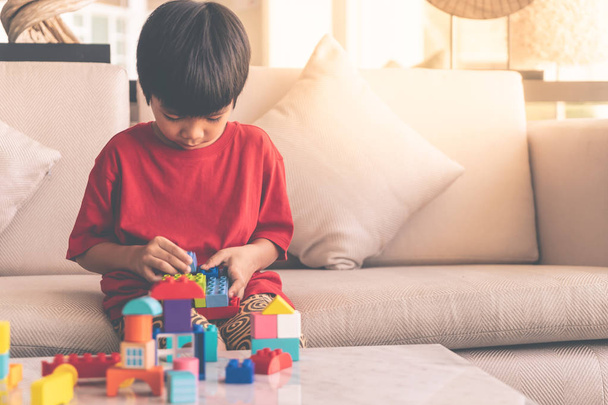 Felice ragazzo accatastamento blocchi giocattolo su un soggiorno per t educativo
 - Foto, immagini
