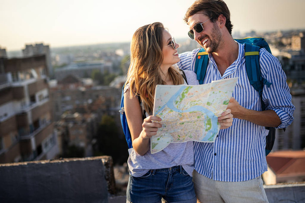 Jovem casal feliz em férias cidade turística com mapa
 - Foto, Imagem