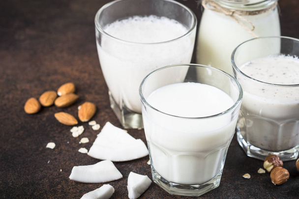 Vegan non dairy alternative milk on dark rusty table.  - Zdjęcie, obraz