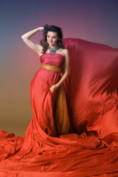 Elegant Fashion Model in Fluttering Red Gown - Fotó, kép