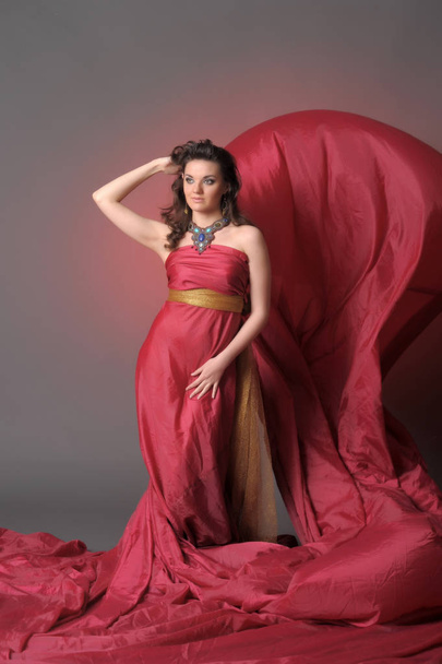 Elegant Fashion Model in Fluttering Red Gown - Valokuva, kuva