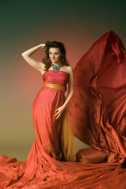 Elegant Fashion Model in Fluttering Red Gown - Foto, Imagen