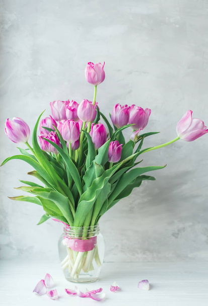Bouquet of lilac fading tulips on a gray background. - Zdjęcie, obraz
