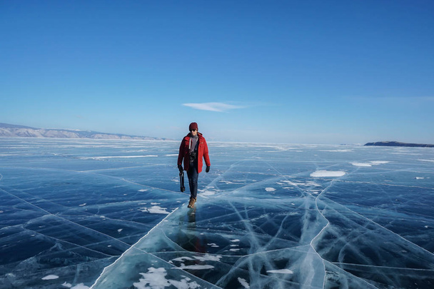 man in winter jacket travel on frozen Baikal lake in Irkutsk, russia in February - Fotó, kép