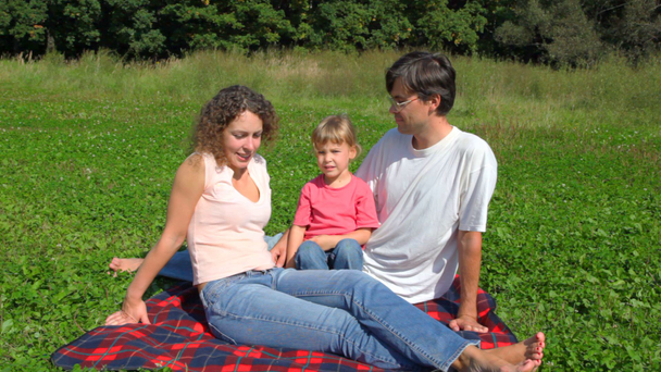 Heureuse famille est assis sur le terrain dans le parc d'été
 - Séquence, vidéo