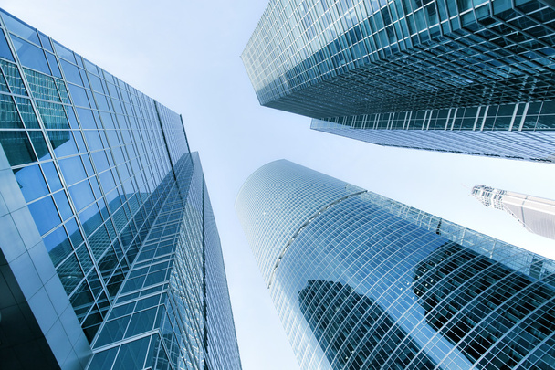 Panorámás és perspektivikus széles szög kilátás acél kék háttérrel, magas emelkedik épület felhőkarcoló éjszaka üzleti koncepció a sikeres ipari építészet a modern futurisztikus belvárosában - Fotó, kép