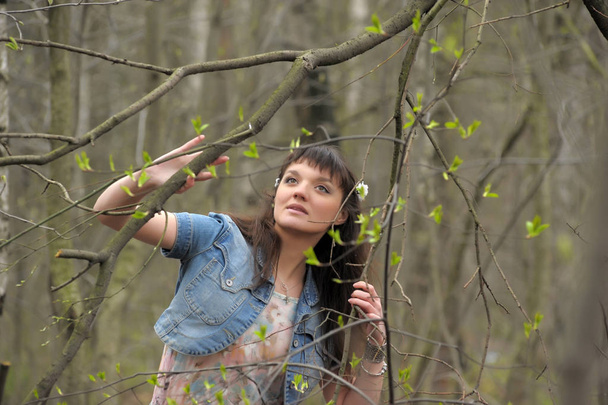 a girl in a light dress and denim jacket in the forest among the - Foto, imagen