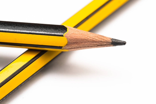 Bleistiftspitze aus gelbem Graphit, auf einem anderen Bleistift. - Foto, Bild
