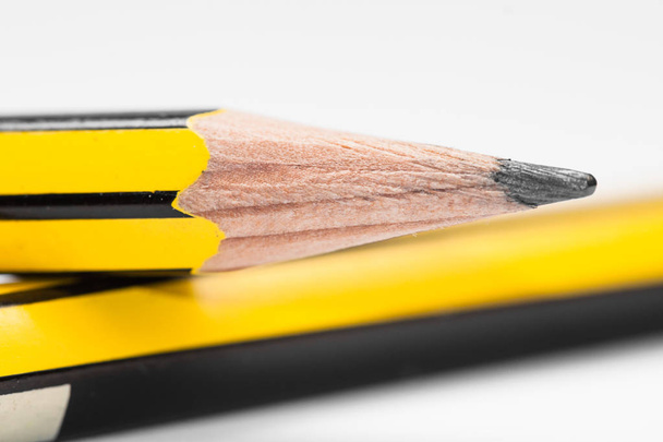 Μύτη από μολύβι κίτρινου γραφίτη, πάνω σε άλλο μολύβι. - Φωτογραφία, εικόνα
