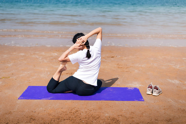 Female friends practicing yoga on the beach - Foto, Imagen