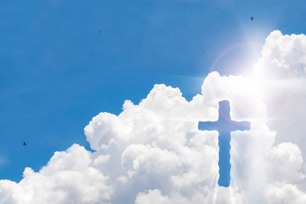 Krusifiksi risti kauniilla taivaalla auringonsäteellä. Jeesuksen Kristuksen pyhä risti pilvissä taustalla
. - Valokuva, kuva