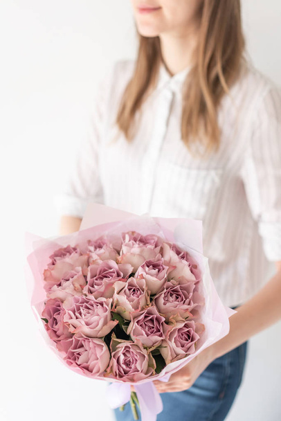 Mono bouquet of roses. Delicate bouquet of mixed flowers in womans hands. the work of the florist at a flower shop. Delicate Pastel color. Fresh cut flower. - Φωτογραφία, εικόνα