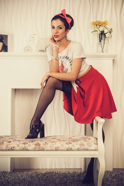 Attractive girl in a red skirt, stockings and a white singlet. Imitation of old photos. - Foto, Imagen