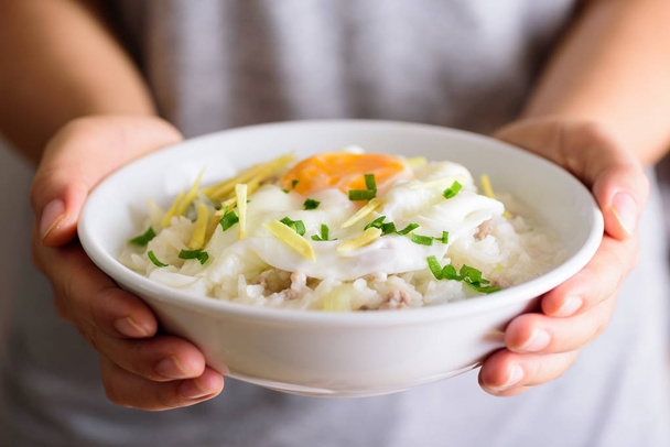 Sopa de arroz tailandés o arroz hervido con cerdo y huevo
 - Foto, imagen
