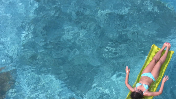 Жінка лежить на надувному матраці у водному басейні
 - Кадри, відео