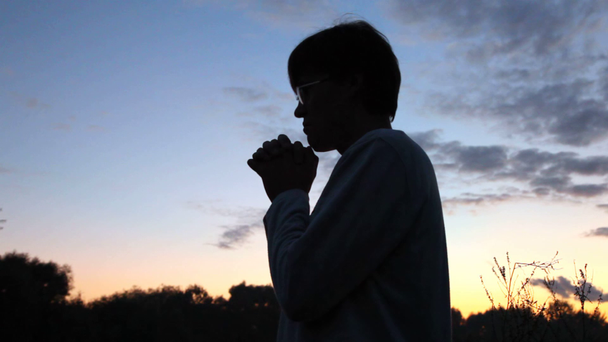 osoba stojí za svítání v parku proti obloze - Záběry, video