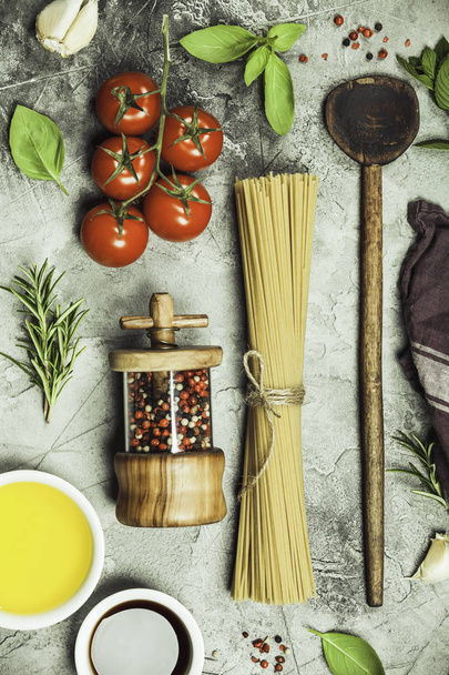 Olive oil, balsamic vinegar, salt, pepper, herbs, pasta, tomatoes on concrete background - Foto, Bild