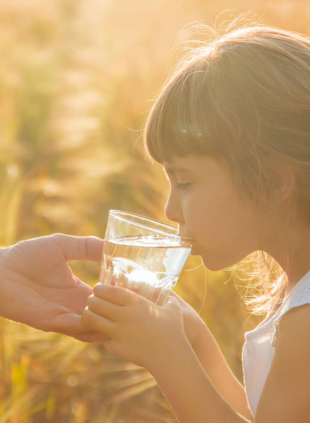 Le père donne à l'enfant un verre d'eau. Concentration sélective
. - Photo, image