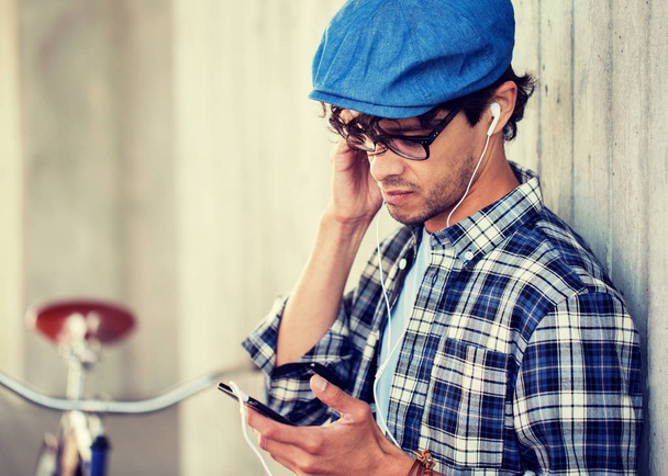 hipster man with earphones, smartphone and bike - Foto, Imagem