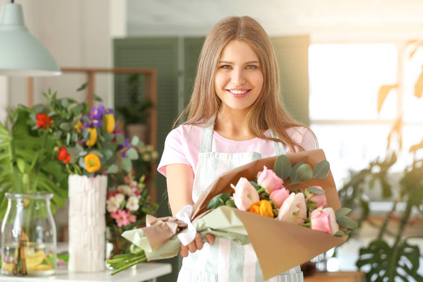 Vrouwelijke bloemist met mooi boeket in de winkel - Foto, afbeelding