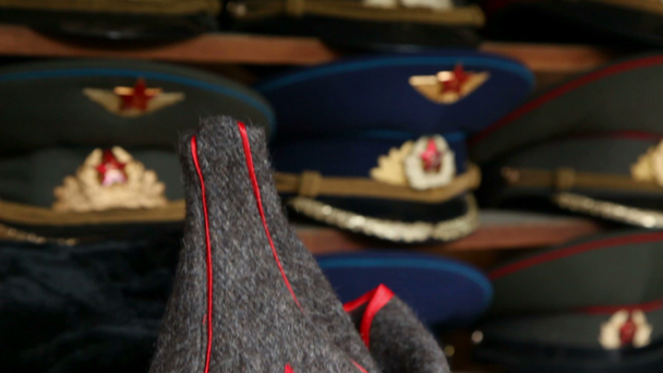 Многие сувенирные военные шапки с советской и российской символикой и буденовкой в магазине
 - Кадры, видео