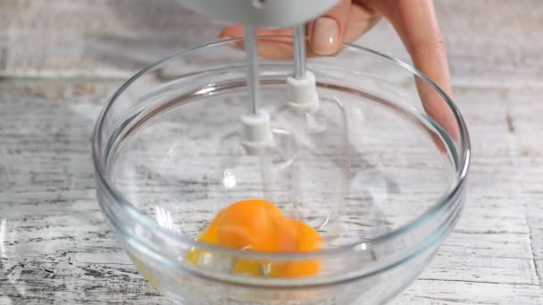 Kobieta bicie żółtka jaj z miksera ręcznego - Materiał filmowy, wideo