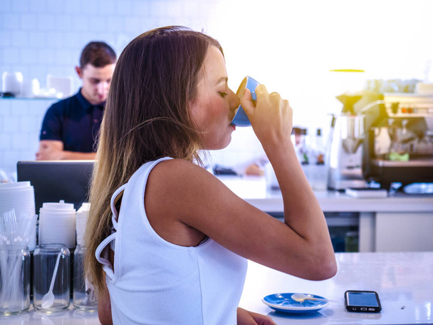Woman in cafe drinking coffee. Happy woman with mug sitting in cafe - Фото, зображення