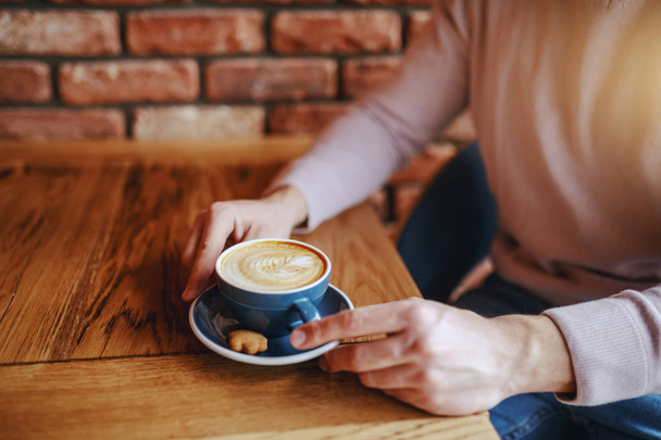 Крупный план кавказца, пьющего кофе в кафетерии утром
. - Фото, изображение