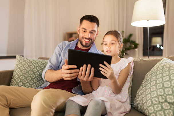 father and daughter with tablet computer at home - Foto, imagen