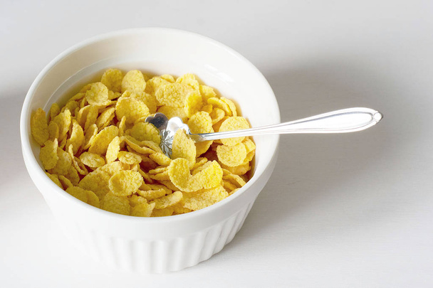Healthy breakfast with cornflakes and milk over white background - Photo, image